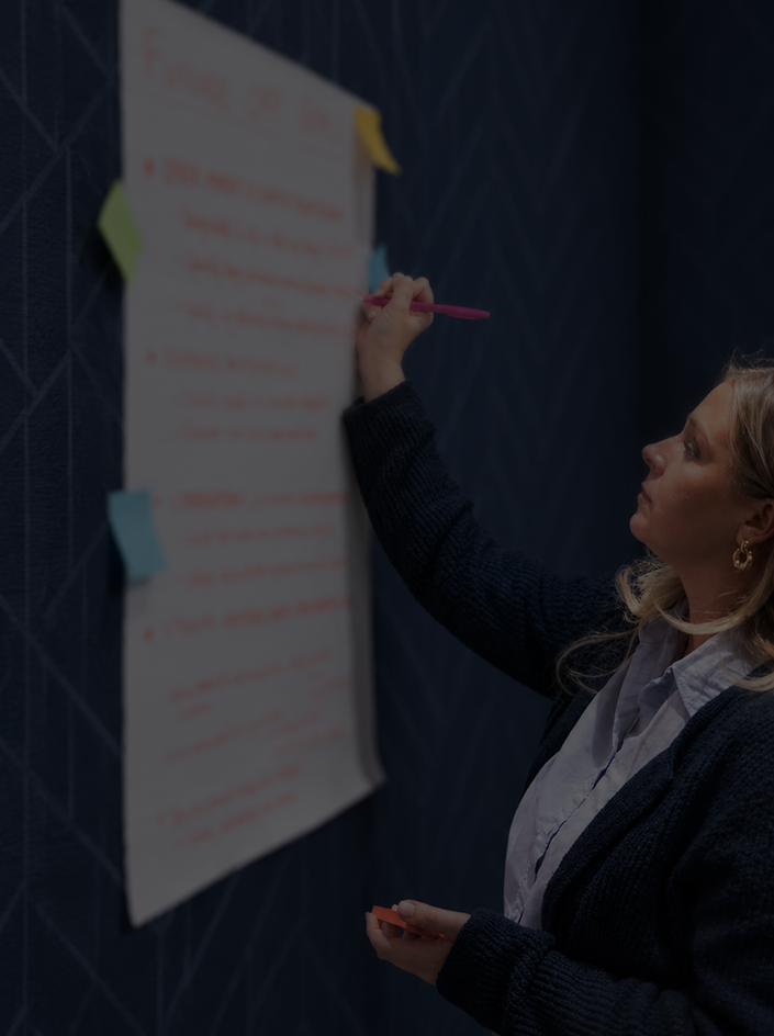 Cobalt team member writing goals on a wall-mounted poster