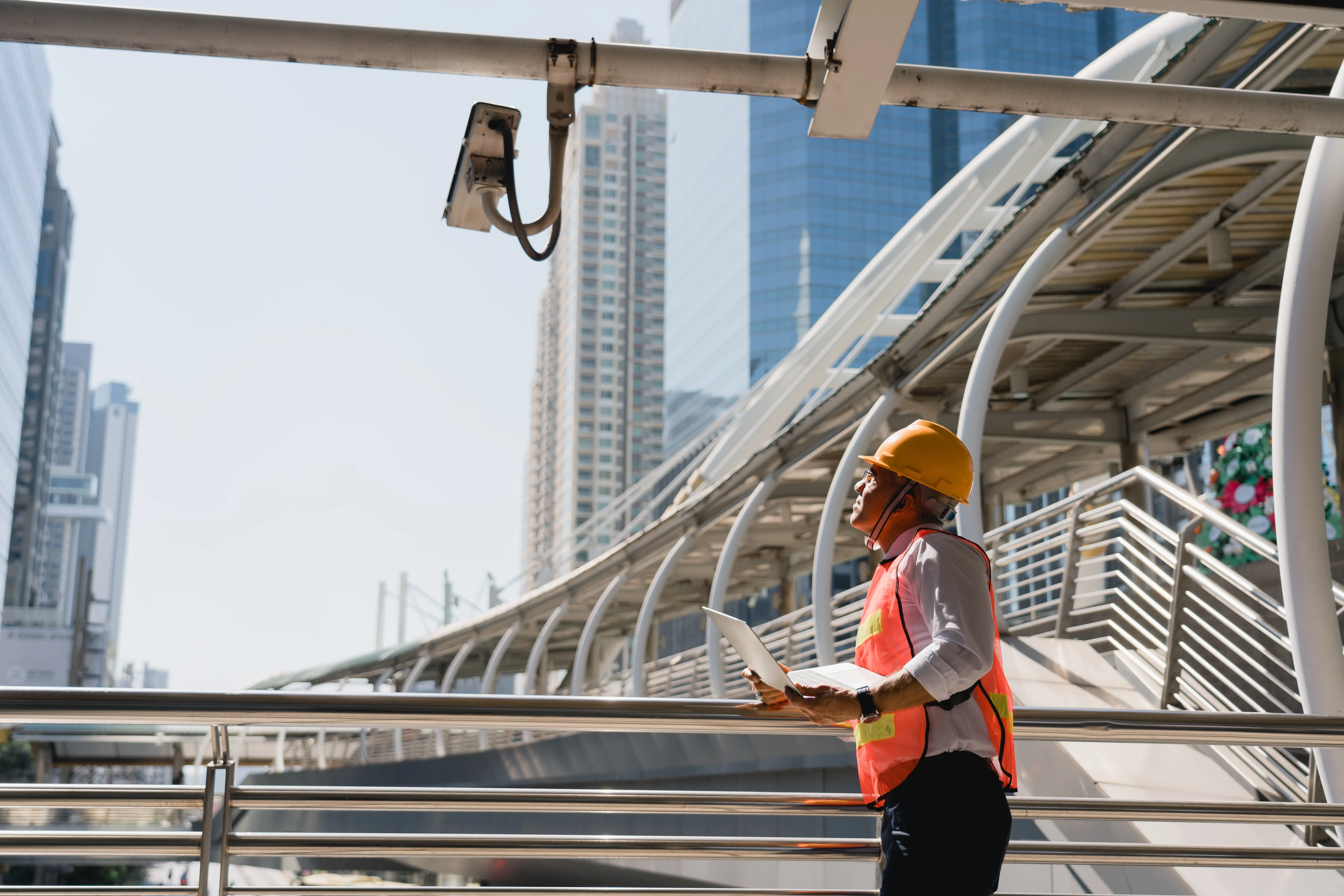 technician inspecting exterior surveillance camera at job site