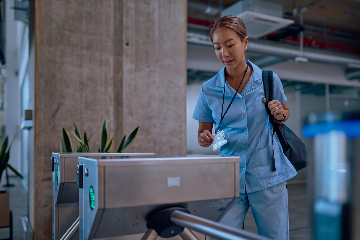 healthcare worker scanning badge at turnstile